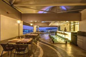 a restaurant with tables and chairs and a view at The Qubice Hotel, Kolhapur in Kolhapur