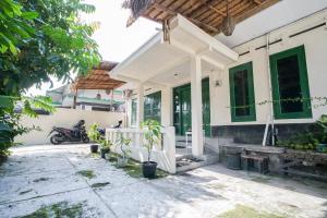 a white house with a motorcycle parked in front of it at Homestay Putri Kencono in Yogyakarta