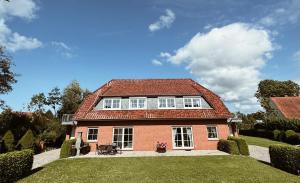 a large red brick house with a roof at Appartment, Ferienwohnung auf Fehmarn in Fehmarn