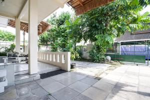 an outdoor patio with a porch and trees at Homestay Putri Kencono in Yogyakarta