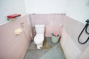 a bathroom with a toilet and a trash can at Homestay Putri Kencono in Yogyakarta
