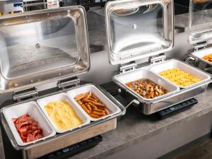 ein Buffet mit Tabletts voller verschiedener Speisen in der Unterkunft THE STILL HOTEL - Opening April 3, 2026 in Ozu