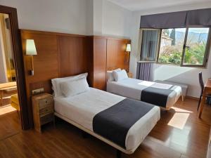 a hotel room with two beds and a window at Hotel Saylu in Granada +62 photos