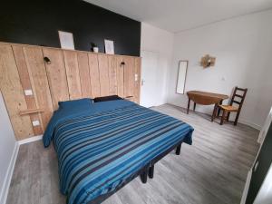 a bedroom with a bed with a wooden headboard and a desk at Chambre double Le Lion d'Or in Nérondes