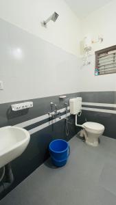a bathroom with a white toilet and a sink at LX premium cottages - Udupi in Udupi