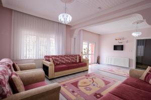 a living room with two couches and a red couch at Ipek Esintisi House in Nevşehir