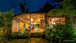 a greenhouse in a garden at night at Hati Padi Cottages in Ubud