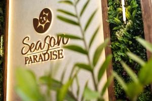 a sign for a garden paradise on a wall at Season Paradise in Thulusdhoo