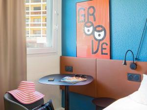 a room with a table and a bed and a window at ibis Marseille Timone in Marseille +108 photos
