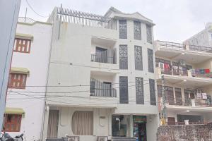 a white building with black accents on it at Serenity By The Ganges in Haridwār