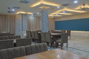 a conference room with tables and chairs and a blue screen at Serenity By The Ganges in Haridwār