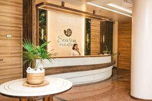 a woman talking on a cell phone in a hotel lobby at Season Paradise in Thulusdhoo