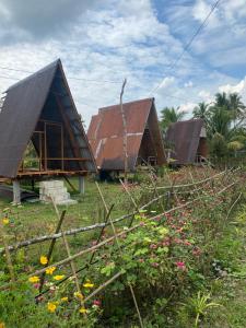 a group of three houses with a roof at Kubo Ni Cesar in Batuan +21 photos