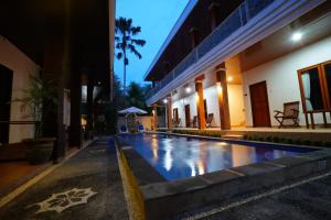 a swimming pool in front of a building at night at The Galuh Pekutatan in Pulukan