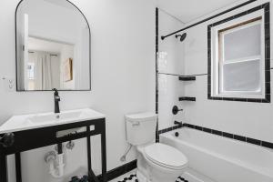 a bathroom with a toilet and a sink and a mirror at Walk to VA DMC 2BR 2 FULL Baths Midtown in Detroit +32 photos