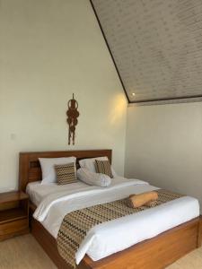 a bedroom with a bed and a cross on the ceiling at Buana Hill in Kubupenlokan