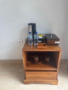 a small wooden table with two water bottles on it at Buana Hill in Kubupenlokan +5 photos