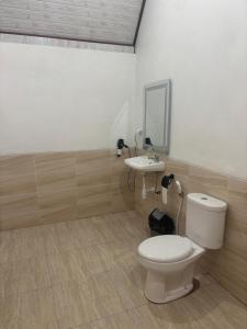 a bathroom with a toilet and a sink at Buana Hill in Kubupenlokan