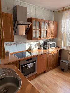 a kitchen with wooden cabinets and a sink at Apartament Aria in Ełk
