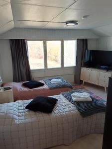 two beds in a room with windows at Pielinen in Lieksa