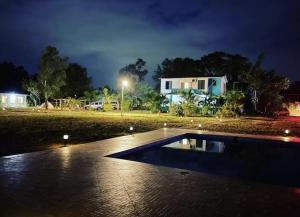 a swimming pool in front of a house at night at Lake Side Mantra in Khamshet