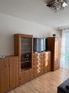 a living room with a large wooden entertainment center at Apartament Aria in Ełk