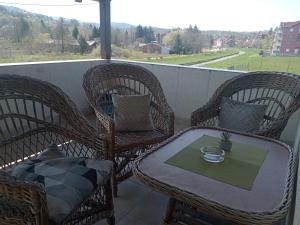 a table and chairs on a balcony with a view at Vila Cezar in Gornja Toplica