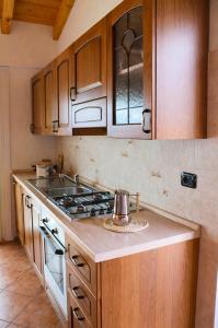 a kitchen with wooden cabinets and a stove top oven at Residenza Roggiolo in Luino +6 photos