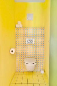 a bathroom with a toilet in a yellow wall at Hobel`s Home in Wildalpen +10 photos