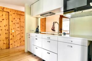 a kitchen with white cabinets and a sink at Hobel`s Home in Wildalpen
