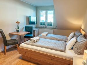a bedroom with a bed and a desk and a table at Apartmenthaus Leuchtfeuer in Norderney