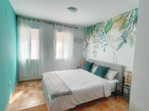 a bedroom with a bed with blue and green walls at Villa Cala Encantada Sea View Apartments with Pool in Calpe