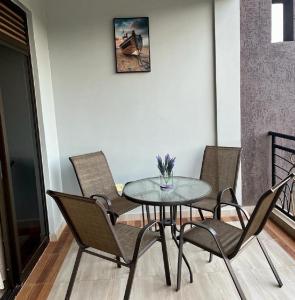 a dining room with a glass table and chairs at KiGALI NORMAL VIEW APARTMENT in Kigali +27 photos