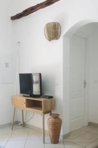 a television on a wooden table in a room at Résidence Canava in Bonifacio