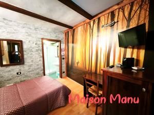 ein Schlafzimmer mit einem Bett und einem Fernseher an der Wand in der Unterkunft Maison Manu in Perosa Argentina