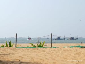 a sandy beach with boats in the water at Avish Dubbansasi Beach stay Resort Gokarna in Gokarn