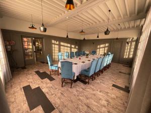 a dining room with a long table and blue chairs at Hotel La Chaumiere in Dole