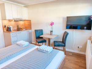 a bedroom with a bed and a table and chairs at Apartmenthaus Leuchtfeuer in Norderney