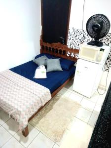 a room with a bed and a machine on the floor at Kitnet Harmonia in Campo Grande