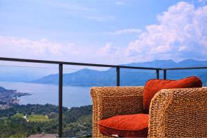 two chairs sitting on a balcony with a view of the water at Residenza Roggiolo in Luino