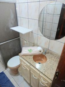 a bathroom with a sink and a toilet and a mirror at Kitnet Harmonia in Campo Grande