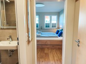 a room with a bed and a sink and a mirror at Apartmenthaus Leuchtfeuer in Norderney +99 photos