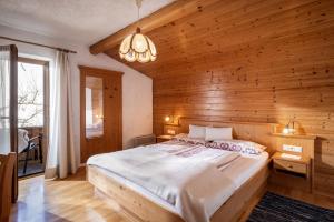 a bedroom with a large bed in a wooden wall at Sophie's Haus in Fügen
