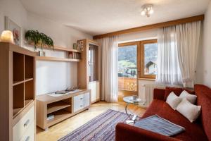 a living room with a red couch and a window at Sophie's Haus in Fügen