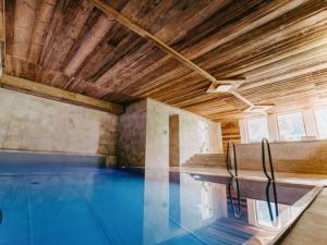 an indoor swimming pool with a wooden ceiling at Stelo Appartments in Gosau