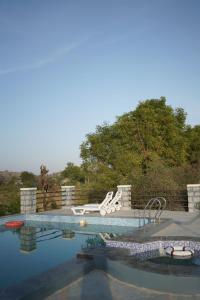a swimming pool with two lounge chairs at Soma Jawai in Bijāpur +22 photos