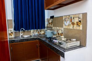 a kitchen with a sink and a stove in it at Malika homestay in Midigama East