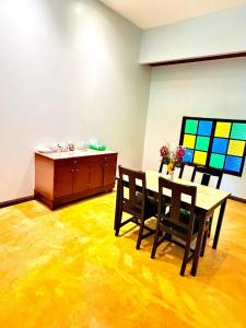 a dining room with a table and chairs and a painting at Amazing beach apartment Phuket in Phuket +7 photos