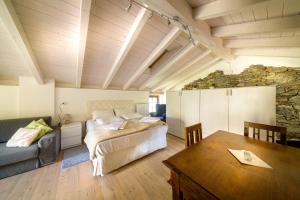 a bedroom with a bed and a couch and a table at Casa Vacanza Nonna Pia I & III in "Piazza Basilica" in Tirano