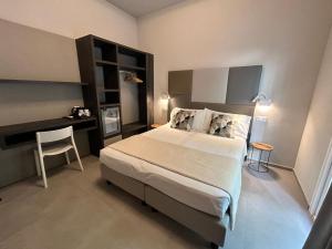 a bedroom with a large bed and a desk at Anastasi Residence in Cervia